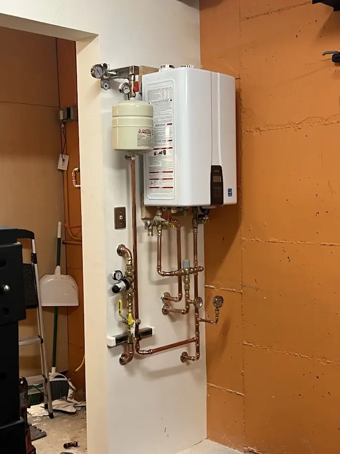 Plumbing technician inspecting water heater connections in Seagoville